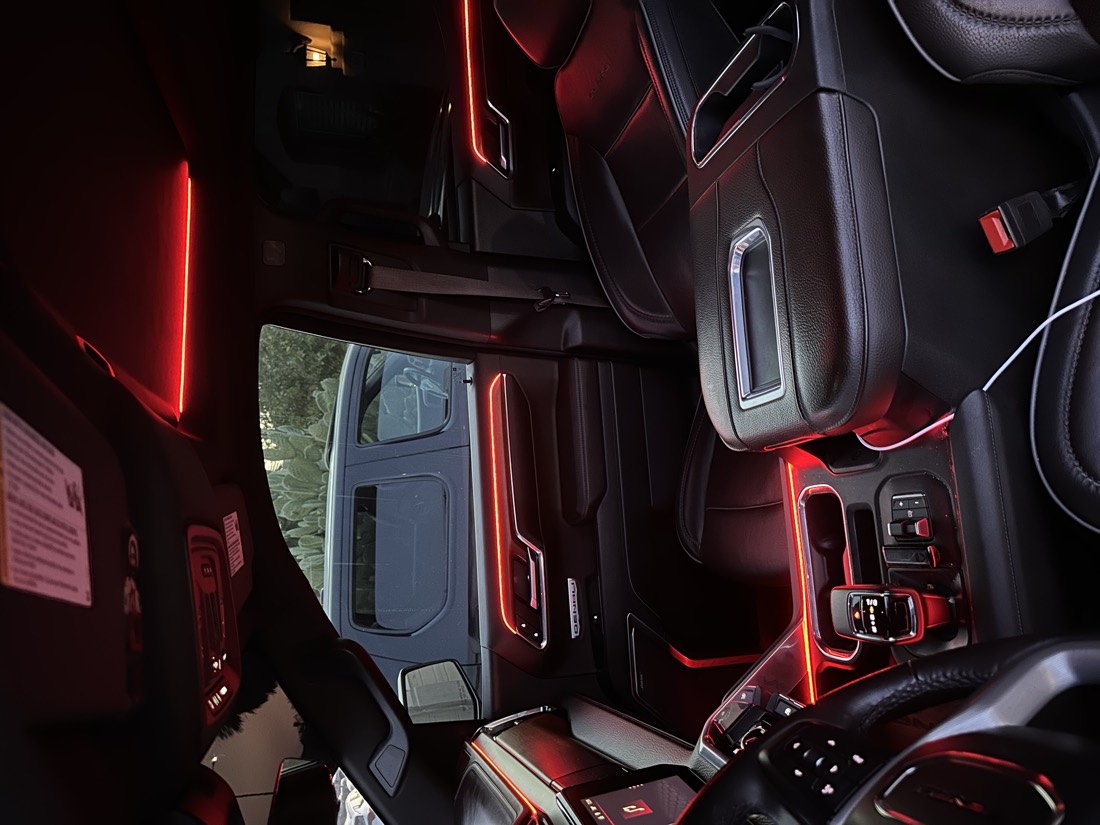 Truck cabin at night lit red, with ambient lines running across the dash, around the vents and down both door cards