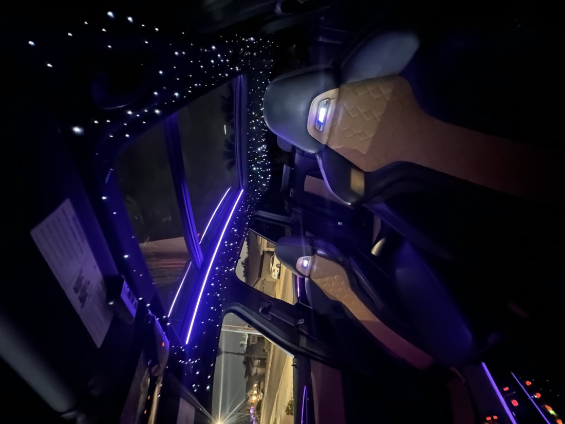 Star ceiling packed with fiber-optic points either side of a panoramic roof, with a blue ambient line running the length of the cabin