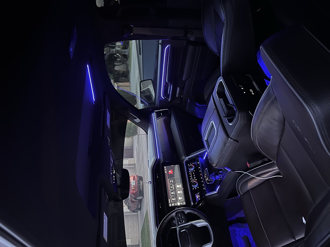 GMC Sierra cabin lit blue, with ambient strips across the dash and doors, a lit line around the sunroof and blue footwells