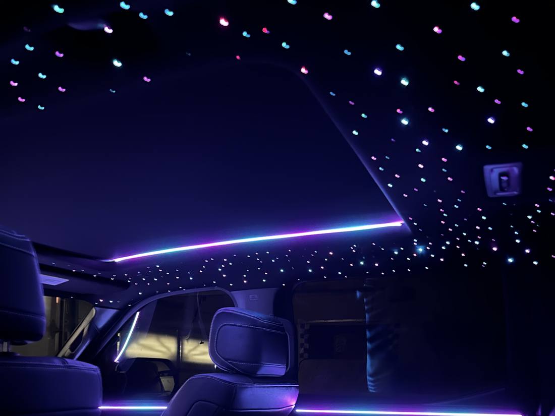 Toyota Tundra cabin with blue and pink stars across the headliner and a lit ambient line around the panoramic roof